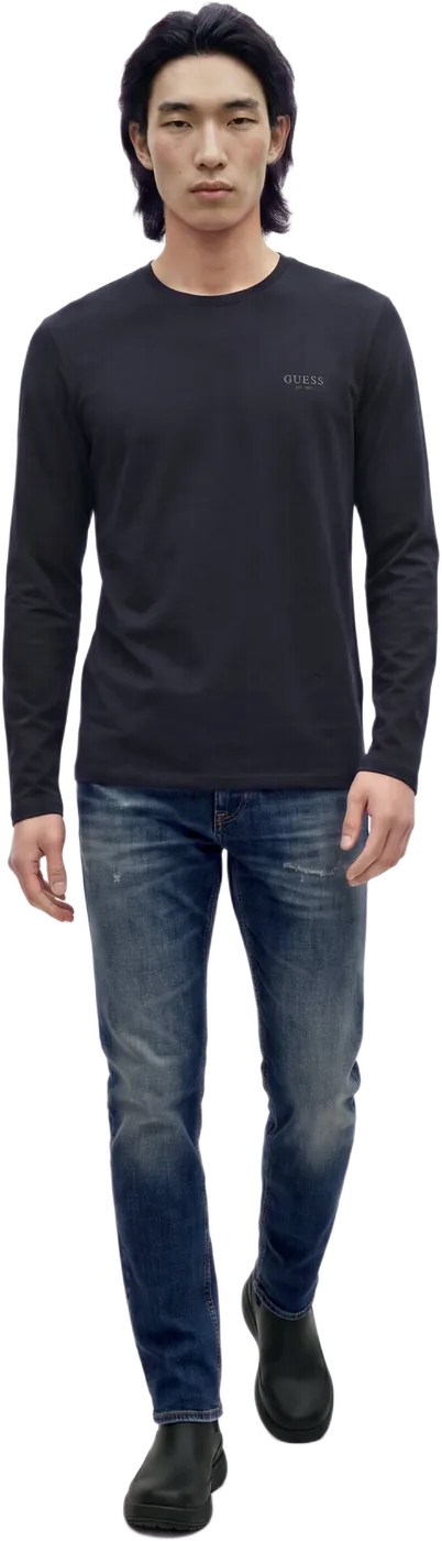 A model in a black long-sleeve top and jeans, walking, full length